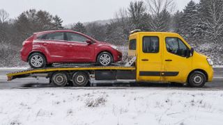 Czerwone auto na lawecie zimą – wymiana koła Mysłowice